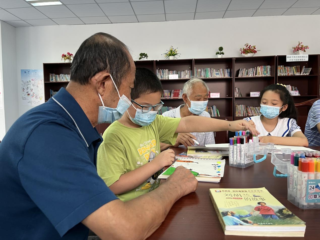 柏堰社區“柏堰小當家”陪伴空巢老人讀書、畫畫。胡祥攝