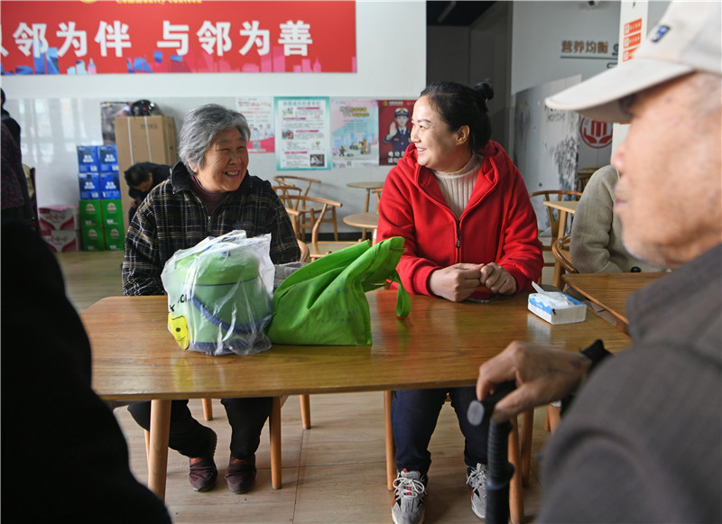 新庄孜街道团结社区邻里帮帮团党员志愿者(右)在老年食堂参与信访矛盾纠纷化解。