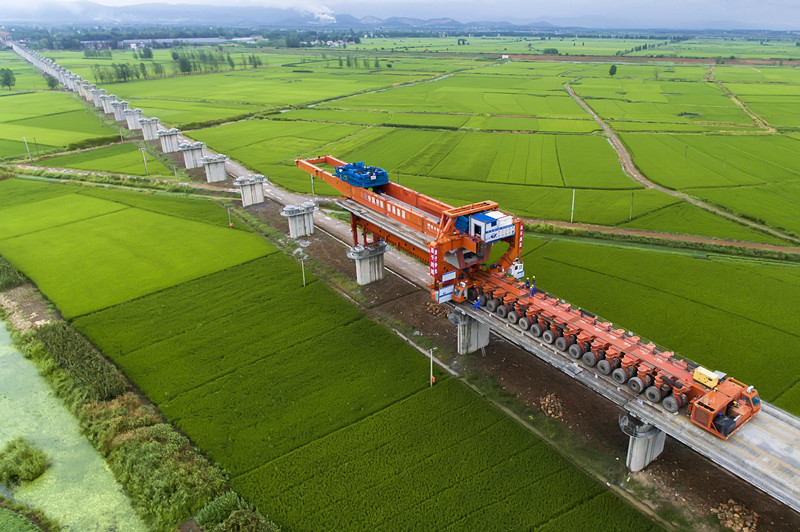 中铁四局900吨箱梁架桥机正在架设商合杭铁路位于安徽省巢湖市境内的柘皋河特大桥，该设备能够实现运架梁一体，一次性架设900吨箱梁。