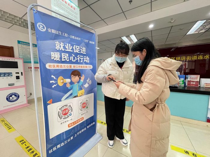 社区工作人员向居民介绍就业促进暖民心行动  方舢 摄