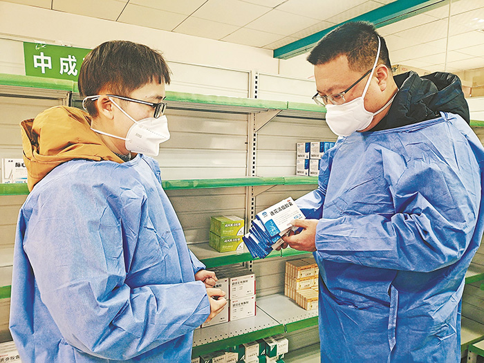程小龙（右）在社区卫生服务中心药房查看药品使用和库存情况。雨山区委宣传部供图