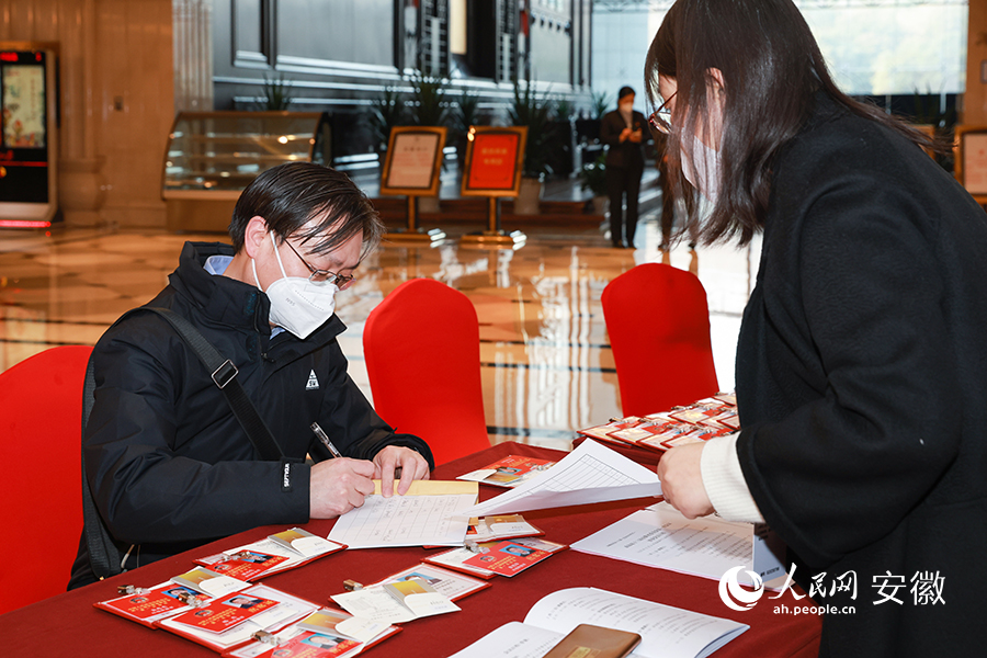政协委员现场登记领取会议材料。人民网 张俊摄