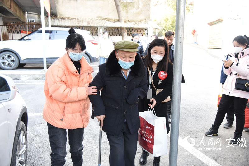 方烨和志愿者一起搀扶着丁龙回家。人民网 李希蒙摄