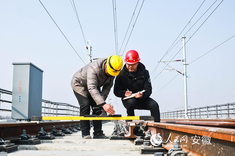 郭克华拿着笔记本在滁宁城际铁路一线检查安全工作。人民网 陶涛摄