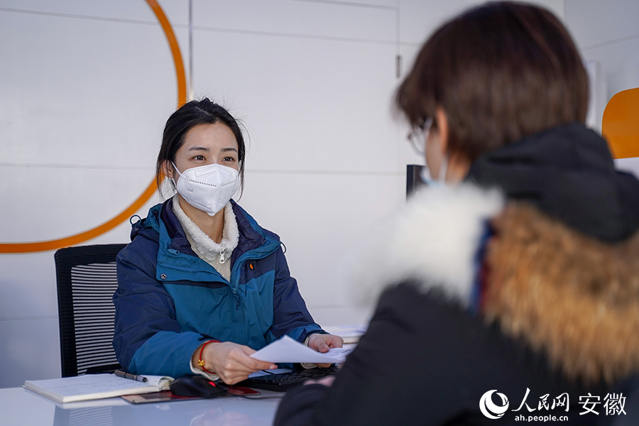 服务大厅里工作人员正在为居民办理业务。人民网 王锐摄