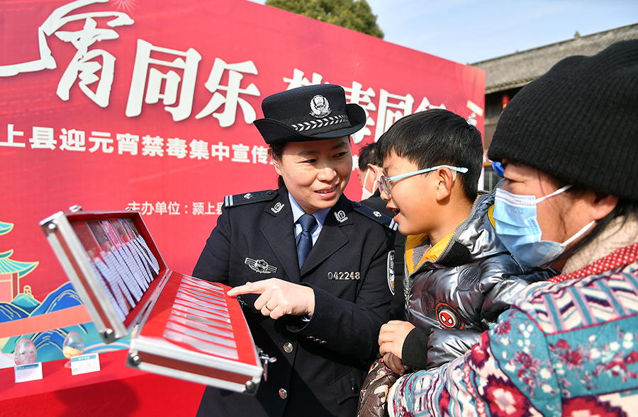 颍上县公安局民警在管仲老街猜灯谜现场向市民展示仿真毒品模具。郑兰鹏摄