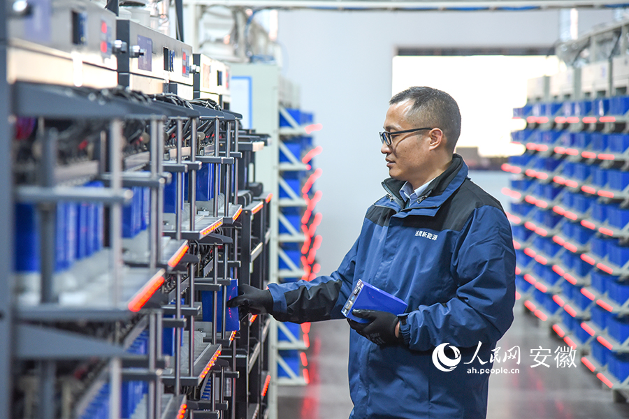 安徽巡鹰新能源集团生产经理程治洋正在电池分容车间巡视设备。人民网 李希蒙摄