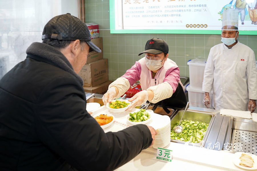 食堂里工作人员正为前来就餐的老年人打菜。人民网 王锐摄