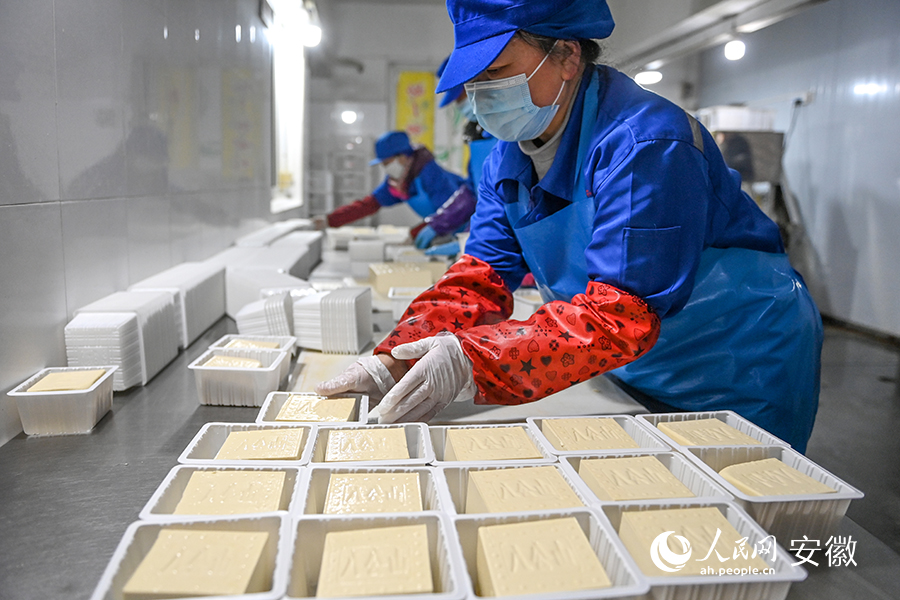 工作人员将豆腐分割后独立包装。人民网记者 苗子健摄