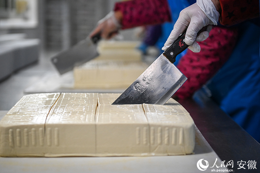 工作人員將豆腐分割成小塊，等待進一步包裝。人民網記者 苗子健攝