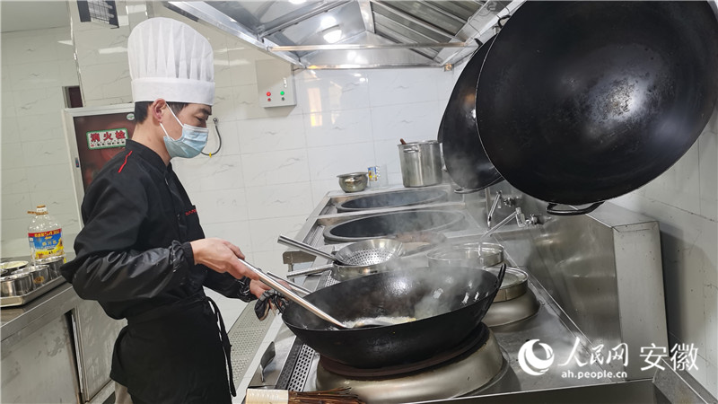 后廚正在烹制菜肴。人民網 胡雨鬆攝