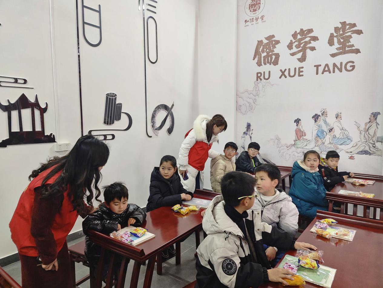 志願者為孩子贈送筆記本。無為市委宣傳部供圖