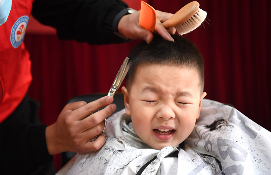 蜀山区翠竹园社区组织理发师在辖区幼儿园剃喜头。