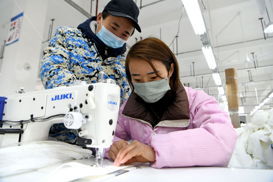 顧承兵（左）、穆臘梅夫妻在堰口鎮產業振興基地內加工服飾。