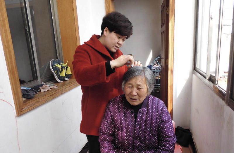 王荣为婆婆打理头发。卢旭 供