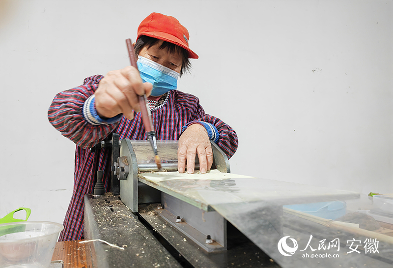 周邊村村民吳美枝正在工廠裡制作艾條，人民網 王銳攝