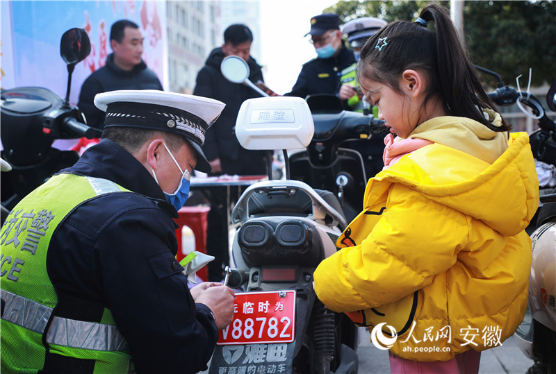 c无为市公安局交管大队志愿服务队正在给当地居民的电动自行车免费上牌。人民网 陶涛摄