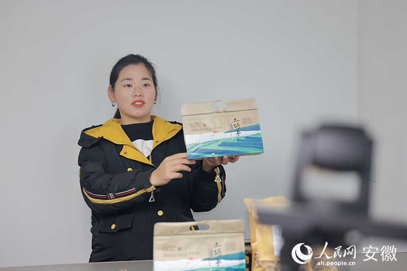 张志菊在摄像头前展示农家土特产。人民网 王晓飞摄