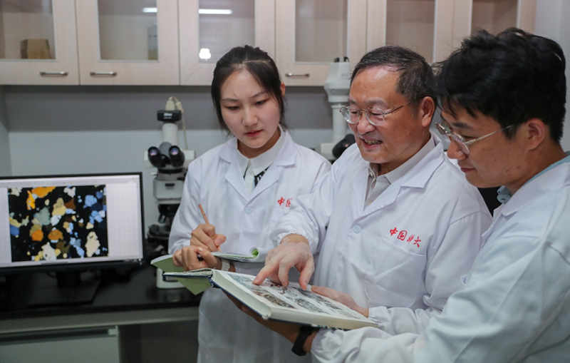 郑永飞院士（中）在实验室与学生一起研究探索矿物岩石形成的科学机理。中国科学技术大学供图
