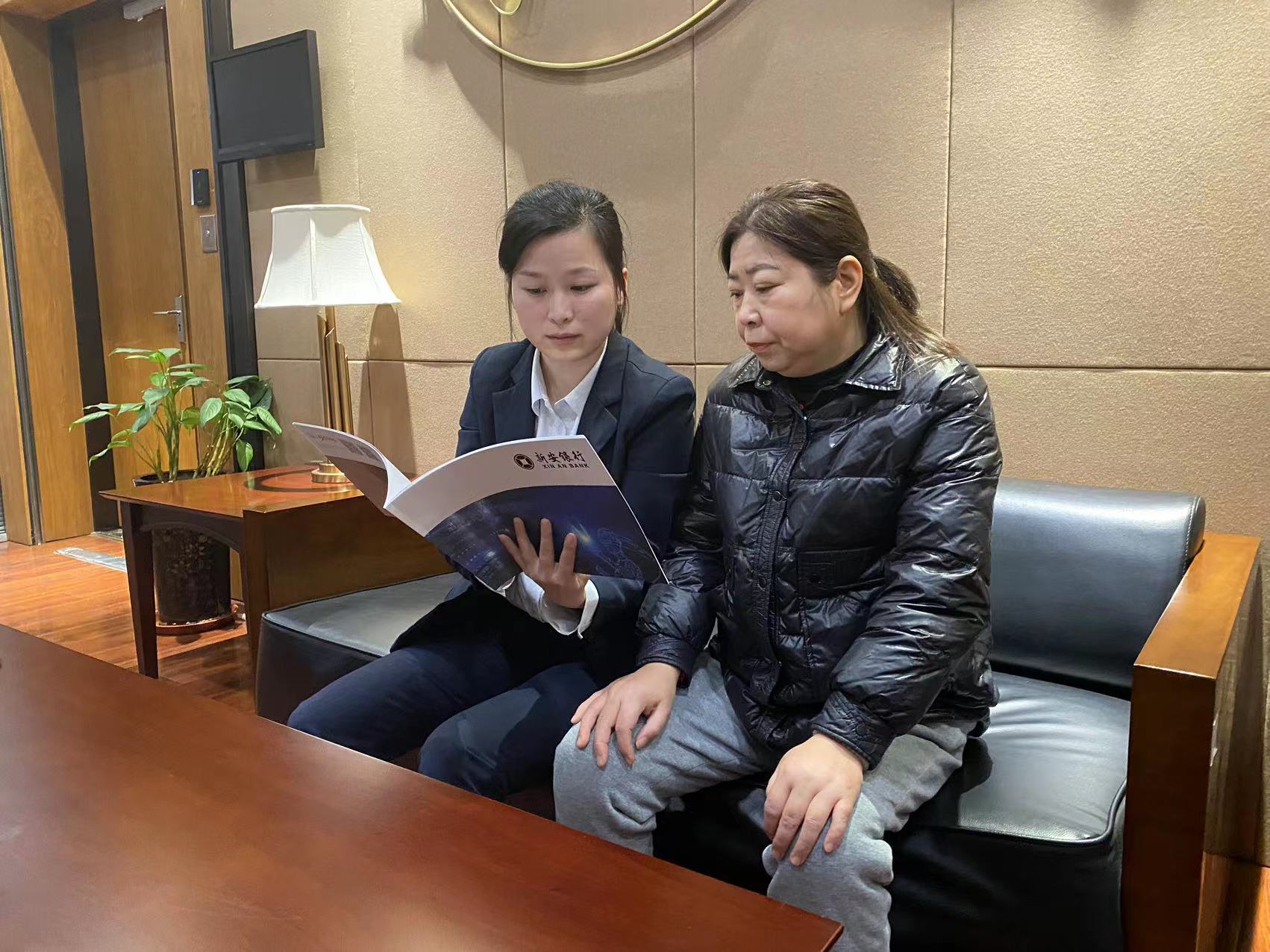 客户经理正在为女性客户讲解贷款政策。新安银行供图