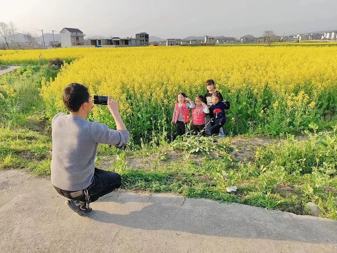 孩子们在油菜花间合影留念。丁满莲供图