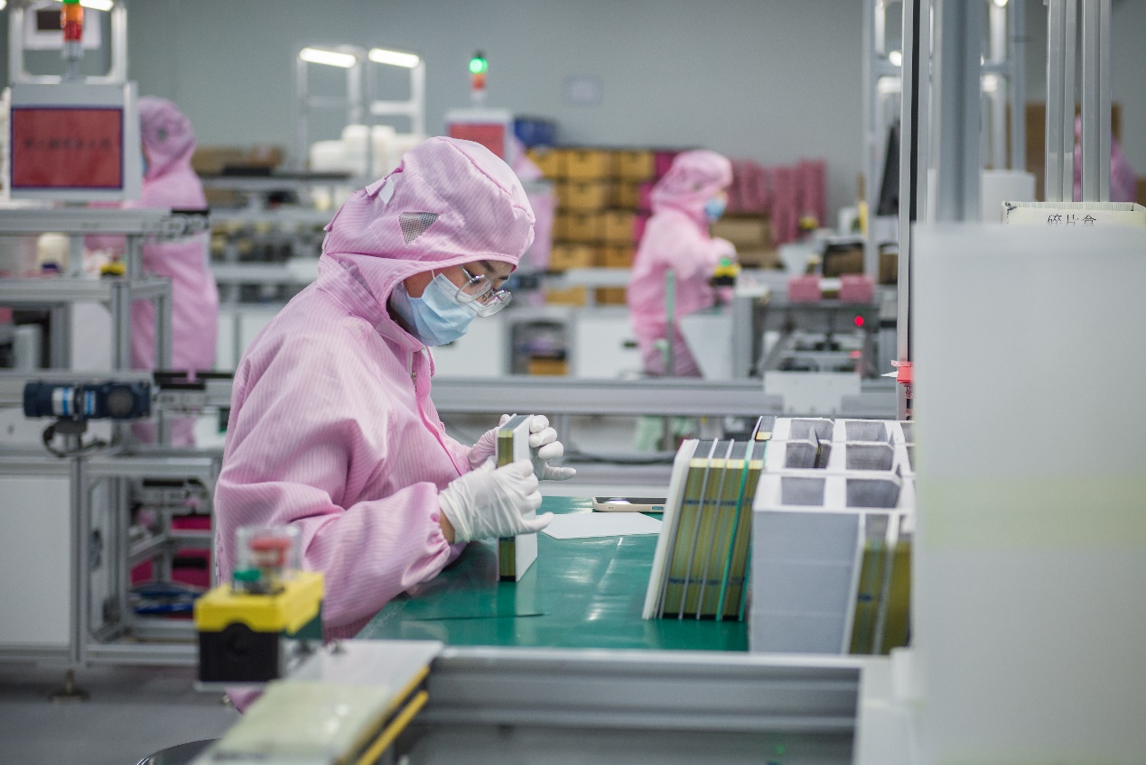 来安县一光伏企业的工作人员整理生产原料。吕华摄
