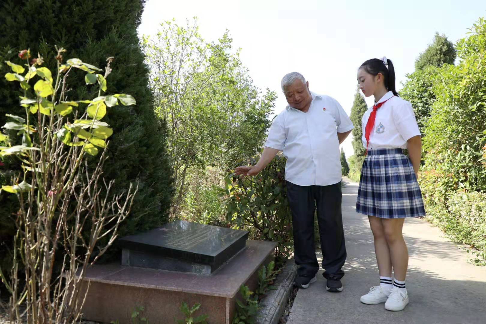 年介涛（左）给小学生讲述烈士事迹。受访者供图