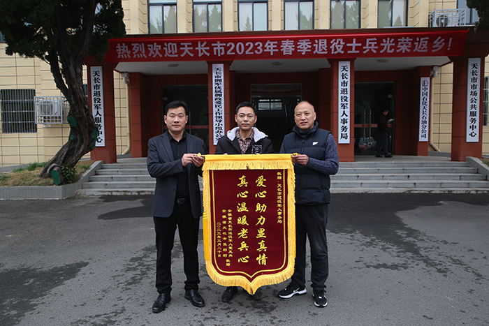 退役军人宣凤兵（中）送锦旗。曹基摄