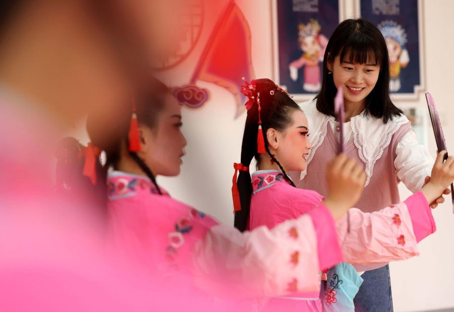 孩子們在老師的指導下練習黃梅戲表演。