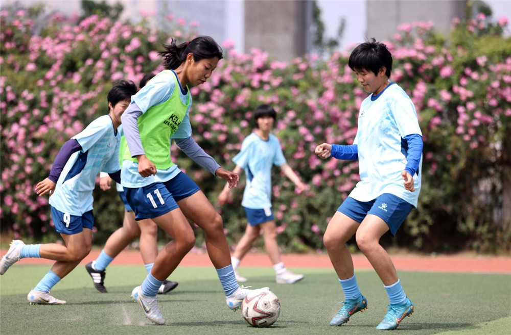 青少年女足隊員在球場上進行足球技能訓練。