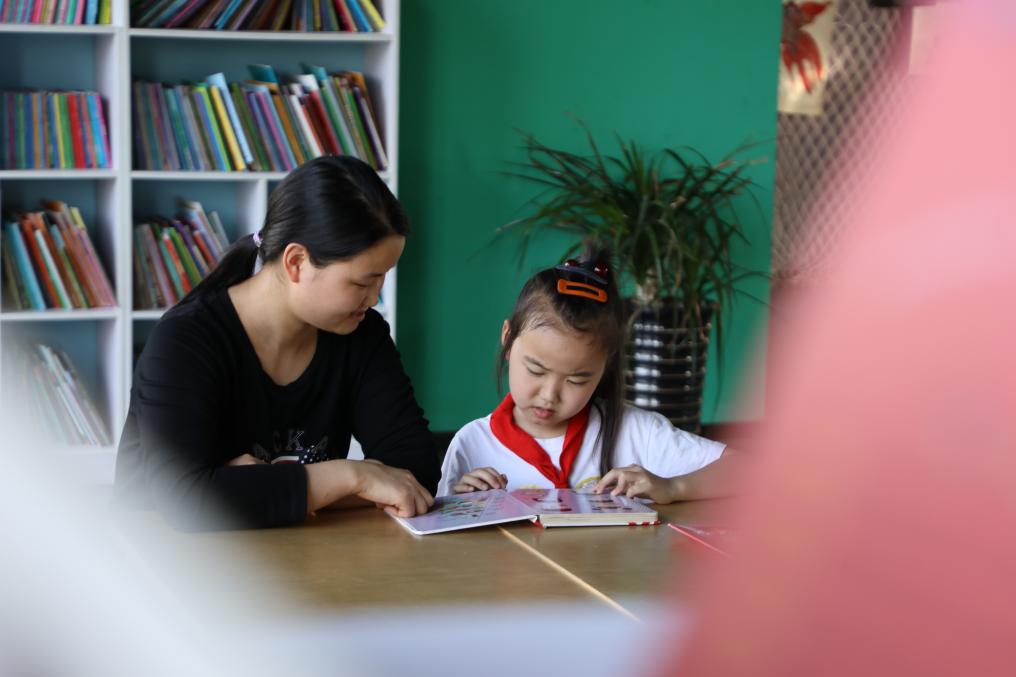 上派镇金星和园城市阅读空间，一名家长陪伴孩子阅读。颜安供图