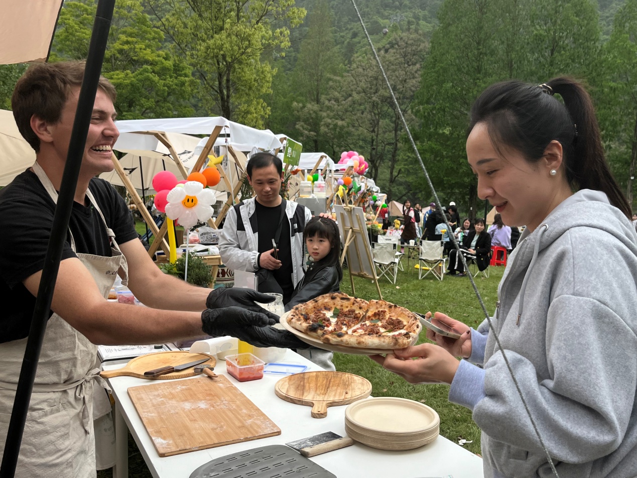 卓文在在齐云小镇市集“摆摊”卖披萨。休宁县委宣传部供图