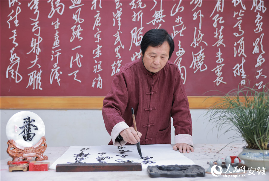 邓之元正在写毛笔字,吴山铁字正是以书法、绘画等技艺为基础。人民网记者 王晓飞摄