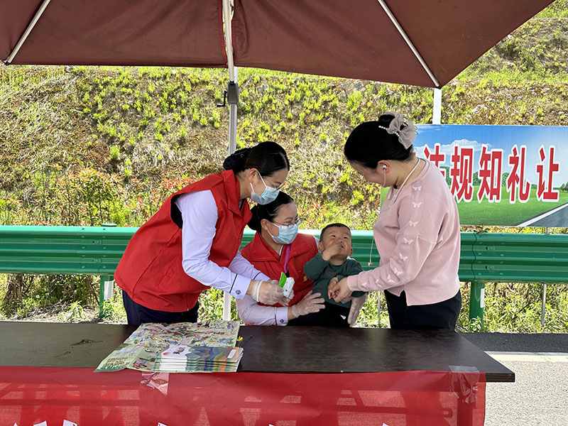 东黄山站志愿者在道口帮助独自驾车的宝妈照顾宝宝。皖通高速供图
