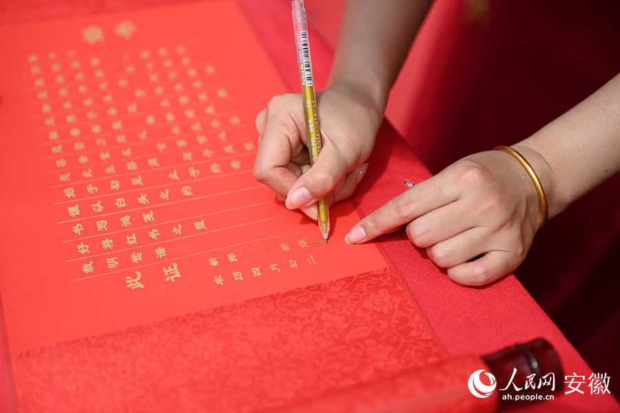 夫妻共同在婚书上签字。人民网记者 苗子健摄