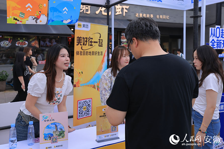活动现场，市民在展台前咨询。人民网记者 王晓飞摄