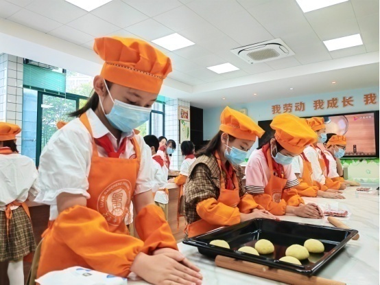 六安市皋城小学烹饪课上，潘雨乐正在制作面包。人民网记者王锐 摄