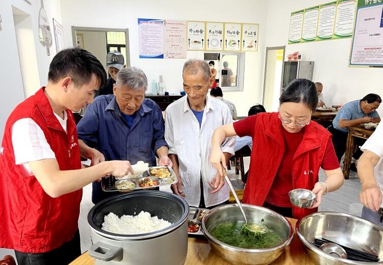 志愿者为老年人打饭。余申发供图