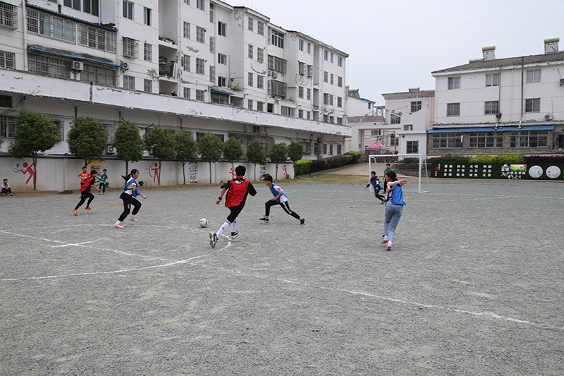 槎小學生在原先砂石場地踢球。蔡磊 攝