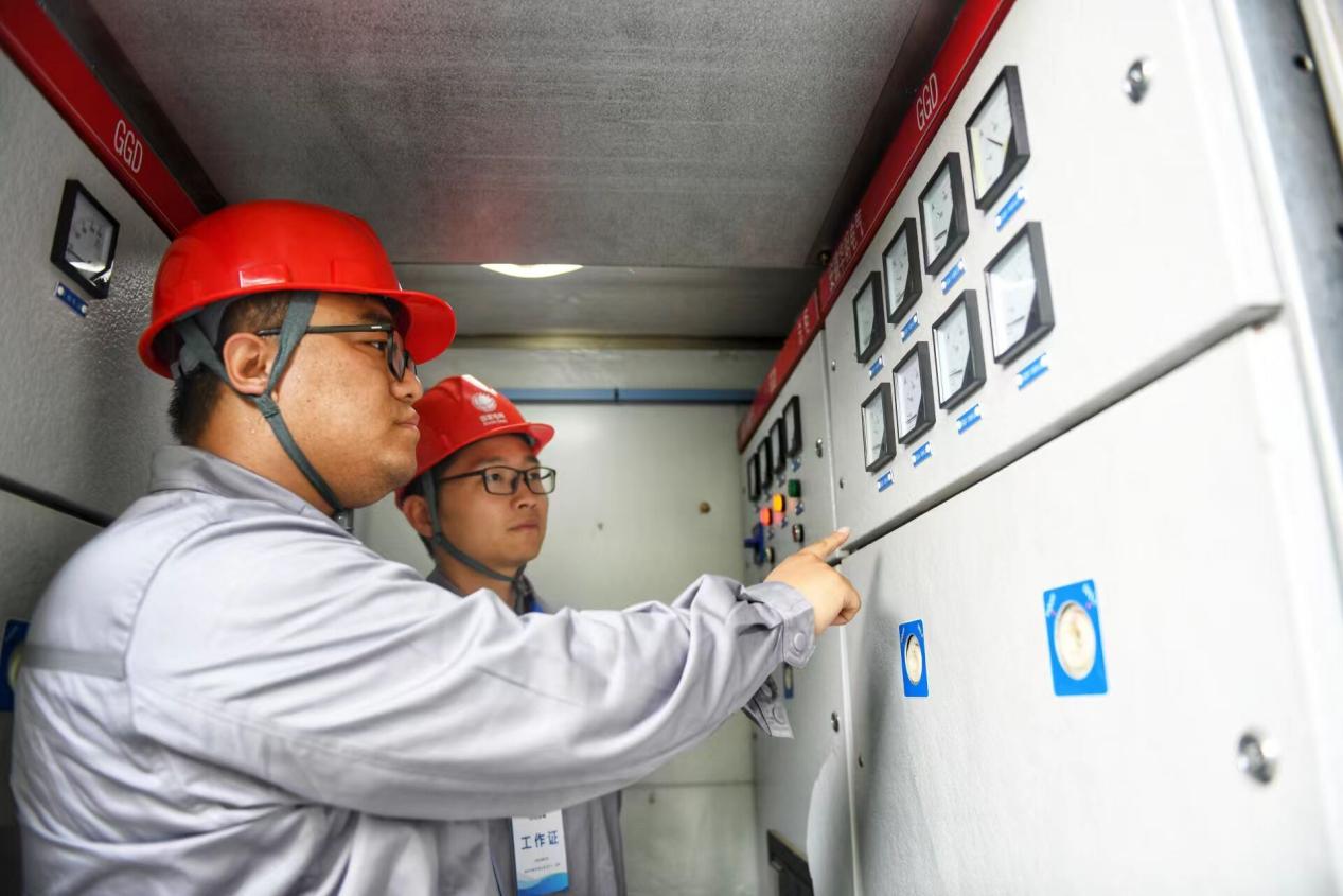 電網技術人員正在檢查考點變壓器運行情況。