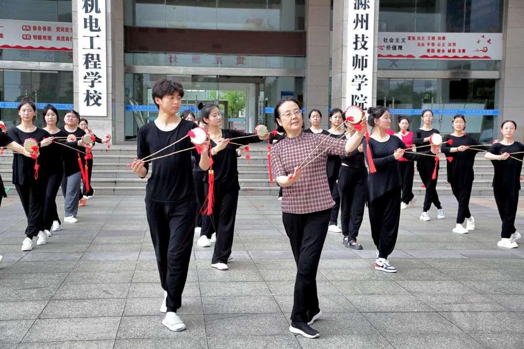 凤阳花鼓省级传承人肖庆红在向学生们传授凤阳花鼓的基本动作。