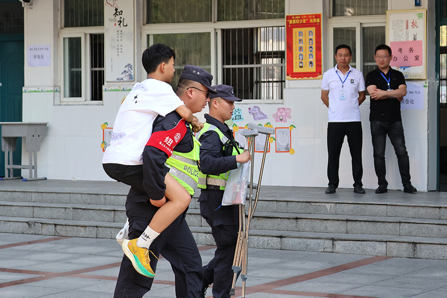 6月14日，在中考颍上縣第一小學考點，一名考生腳受傷，民警背他上考場。
