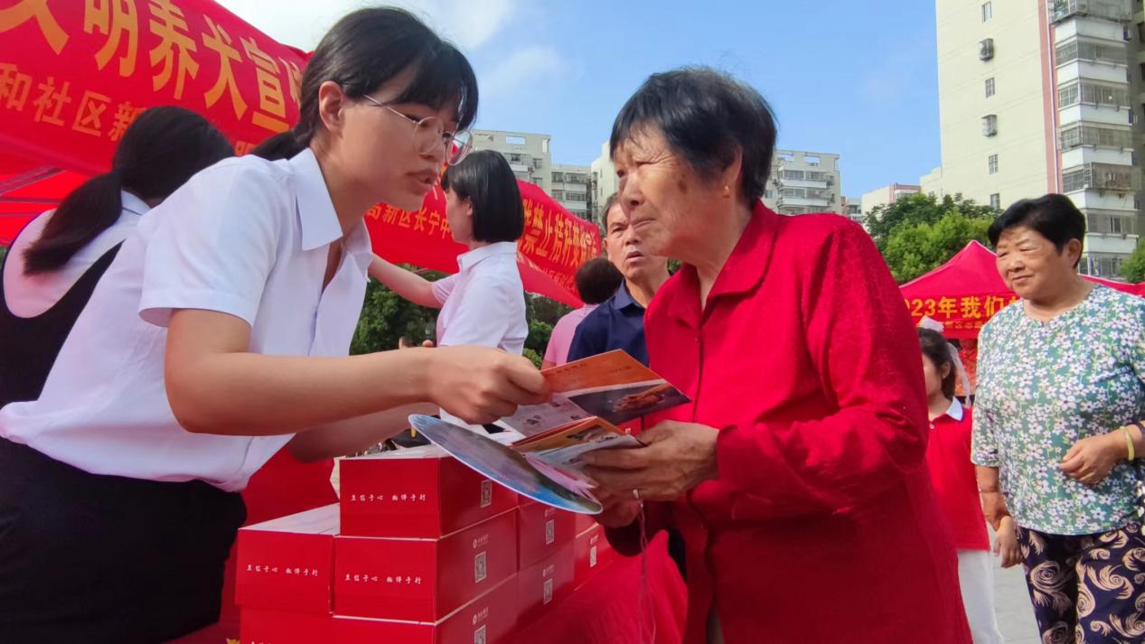 工作人员向来往居民发放防诈宣传手册。新安银行供图