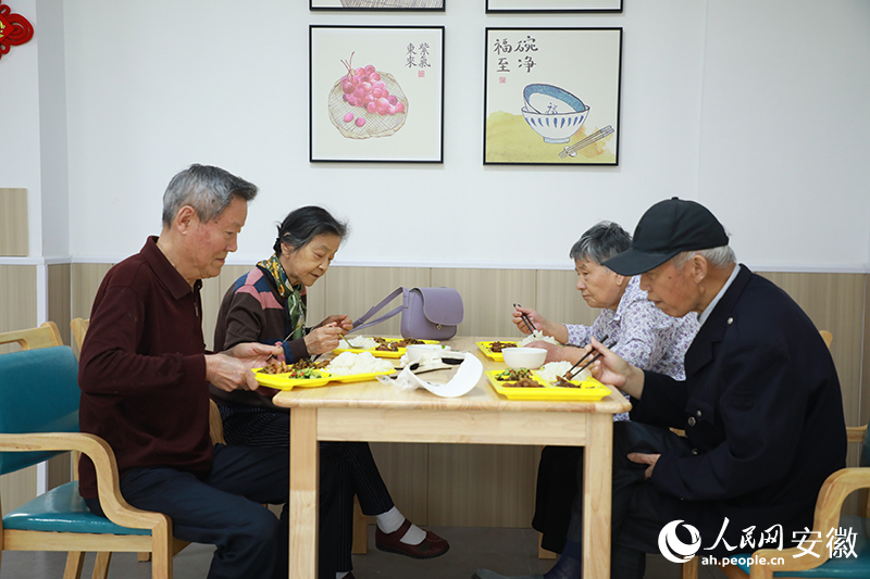 陳桂蘭（左二）和老伴在助餐點就餐。人民網記者 陶濤攝