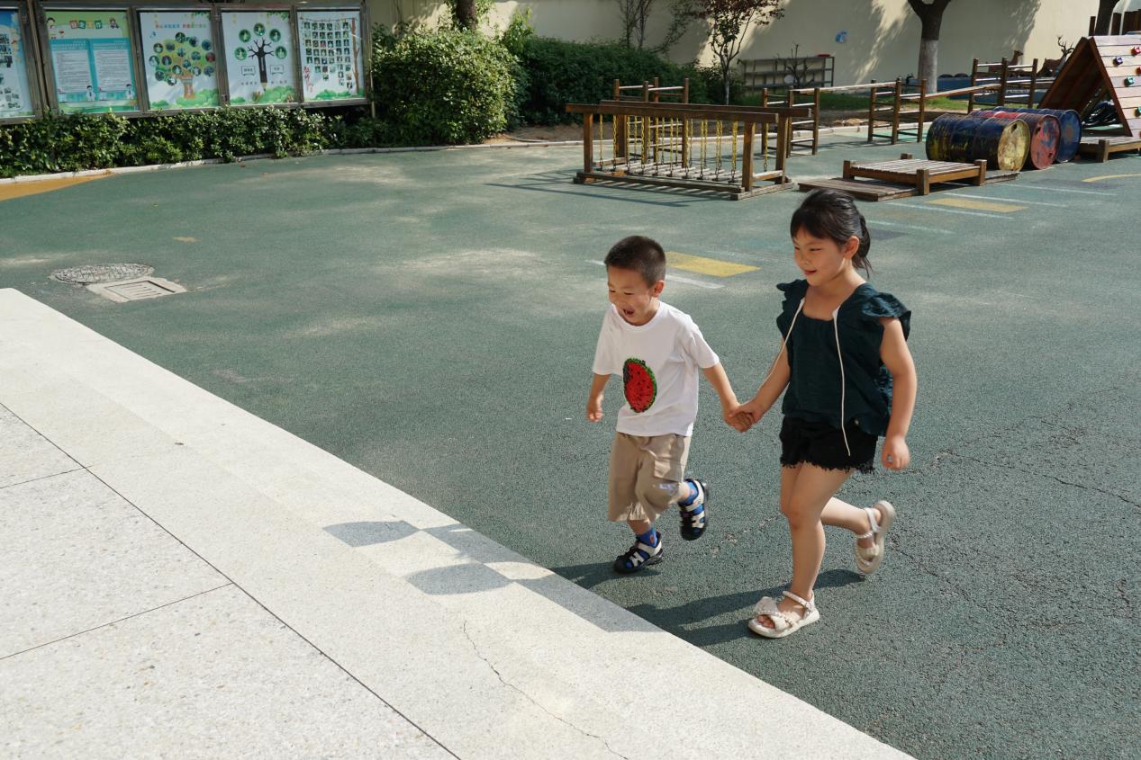 天长市秦栏幼儿园大班幼儿护送小班的弟弟走进班级。缪筱