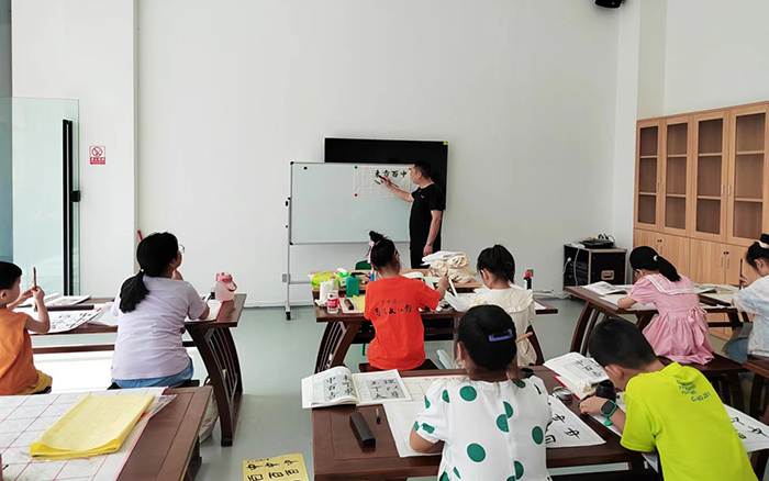 書法興趣班的老師正在講解書法技巧。王友唐攝影