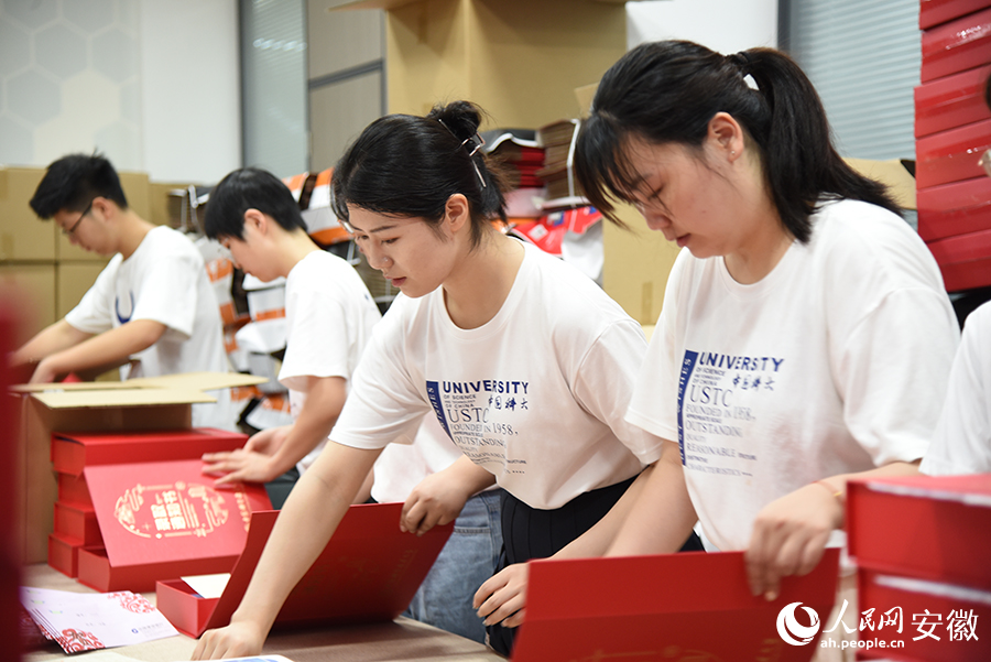 学生志愿者正在打包录取通知书。人民网 李希蒙摄