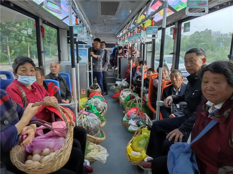 乘坐公交车的菜农将菜篮子整齐摆放。