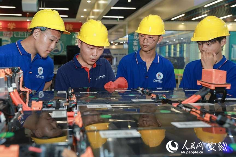 在中国东方教育集团旗下的职教院校，学生正进行拆装新能源汽车电池组实训。人民网记者 张俊摄
