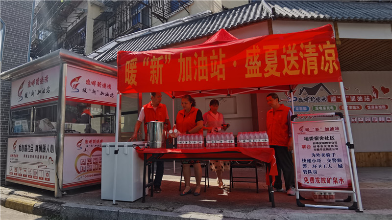 “不老松”志愿服务队队员在街头免费发放矿泉水。人民网 胡雨松摄